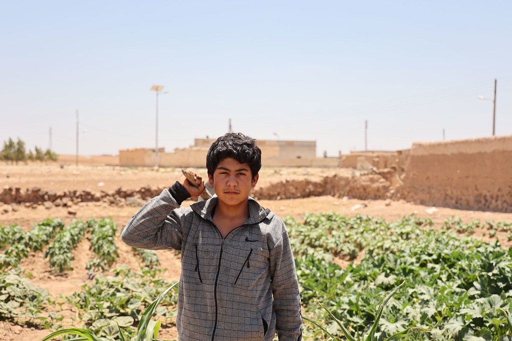 (أرشيف) مراهق يساعد في الاعتناء بحقل عائلته في سوريا.